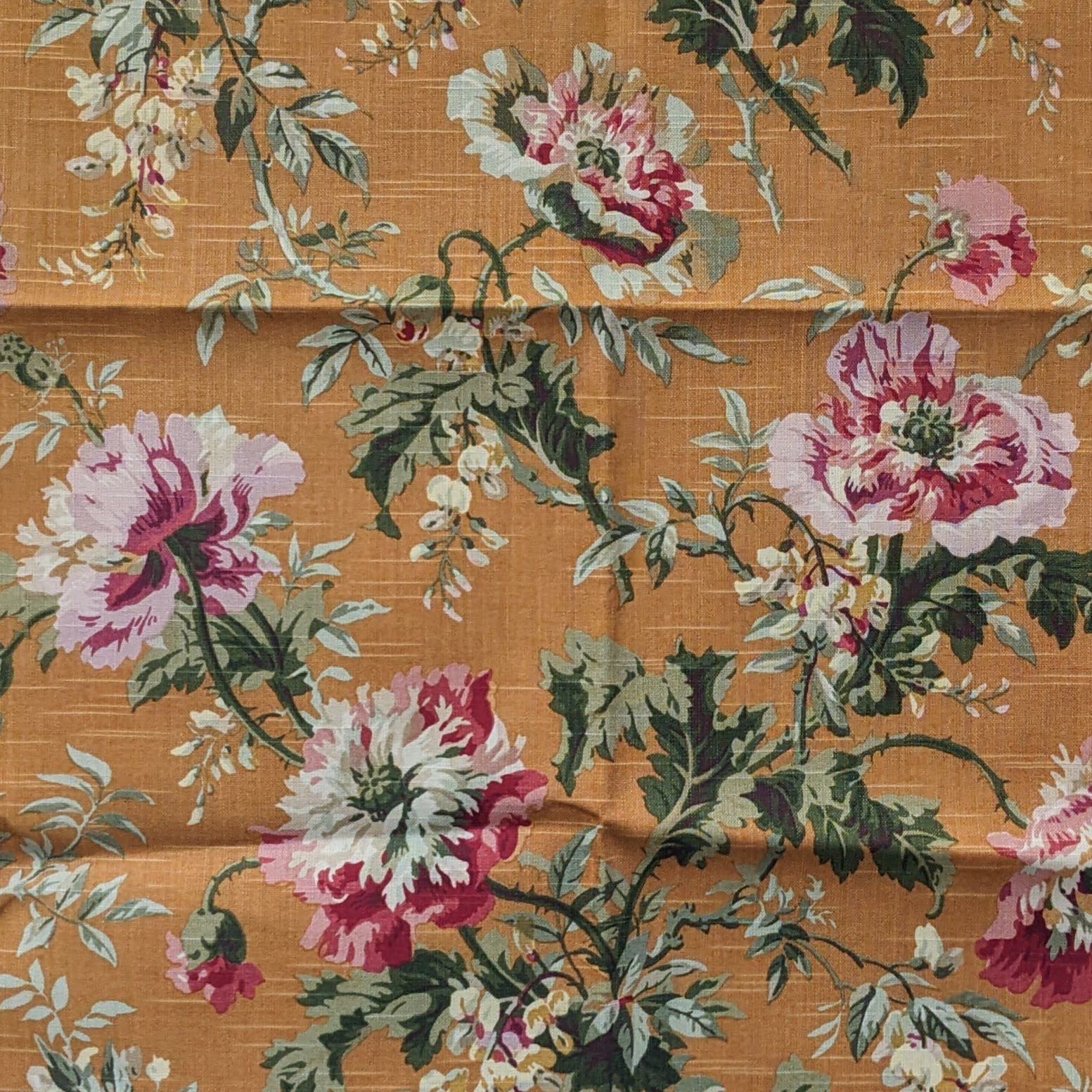 Floral patterned fabric with pink and white flowers on a brown background