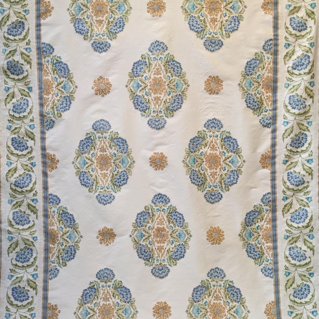 Decorative Persian fabric with intricate blue and gold pattern on a beige background