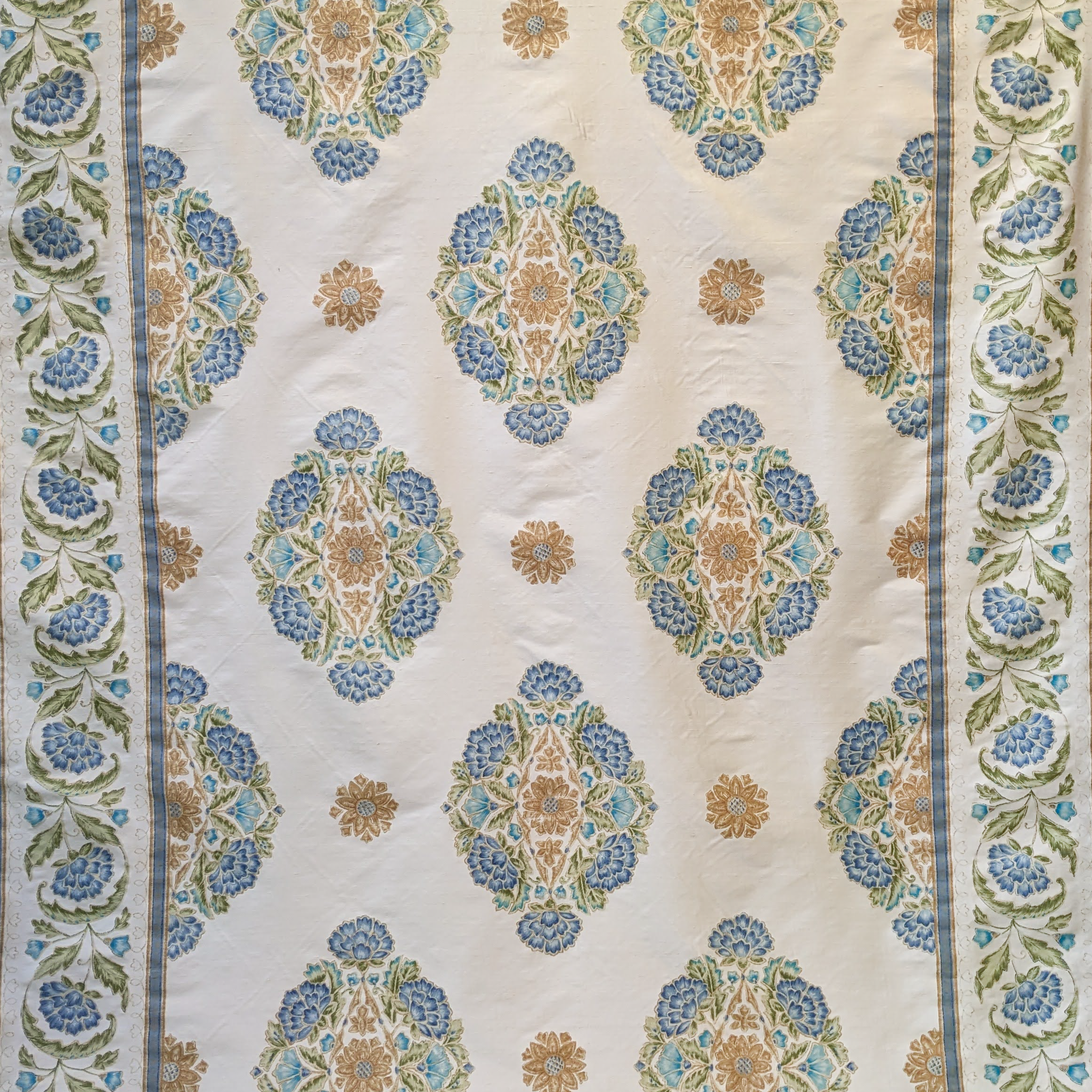 Decorative Persian fabric with intricate blue and gold pattern on a beige background