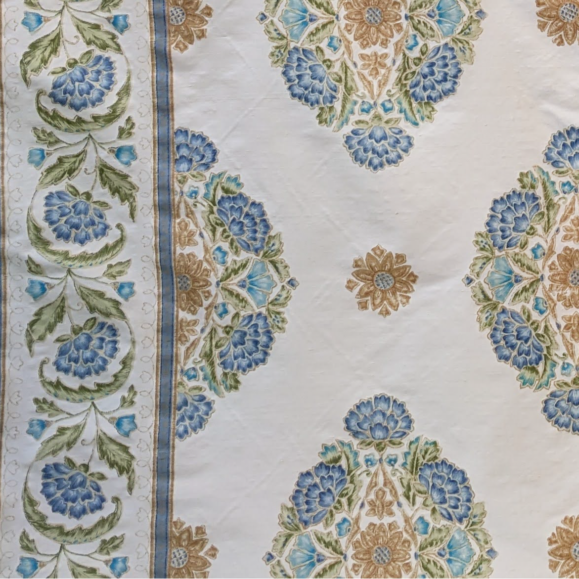 Decorative Persian fabric with intricate blue and gold pattern on a beige background