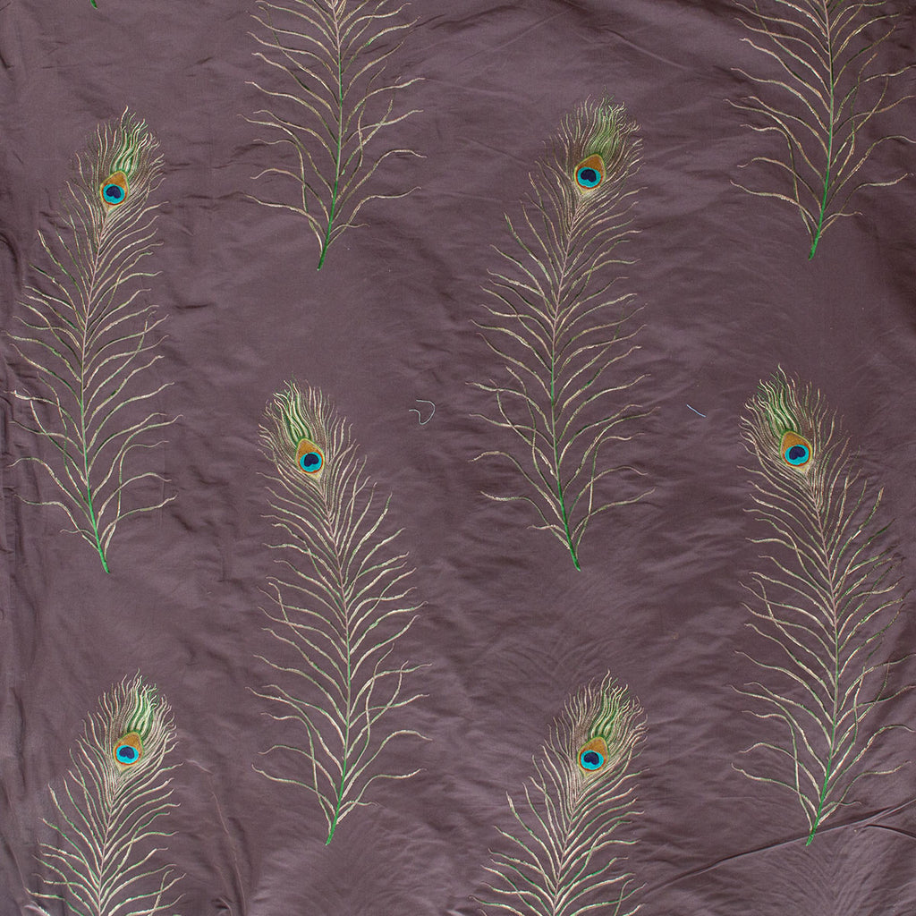Pattern of peacock feathers on a textured purple fabric background