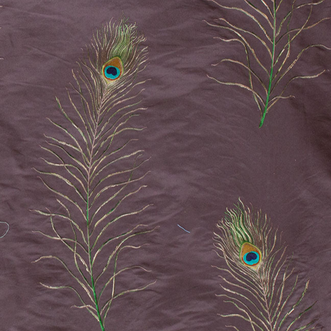 Pattern of peacock feathers on a textured purple fabric background