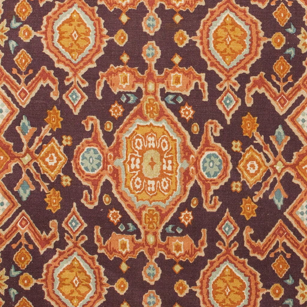 Patterned fabric with Moroccan design in orange, blue, and brown on a dark background