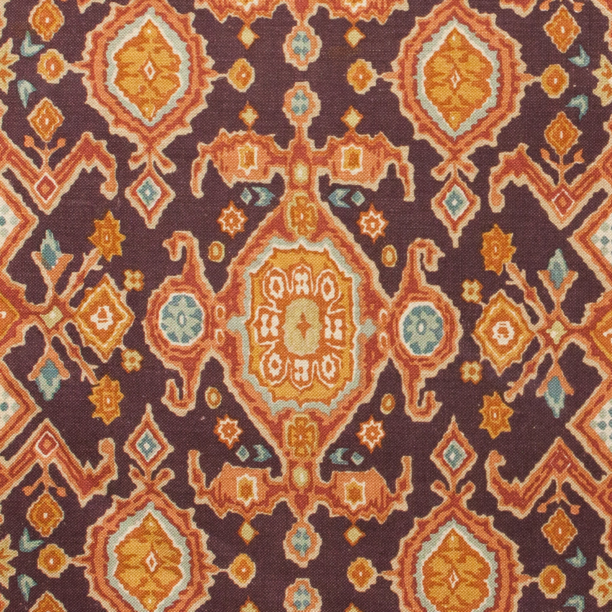 Patterned fabric with Moroccan design in orange, blue, and brown on a dark background