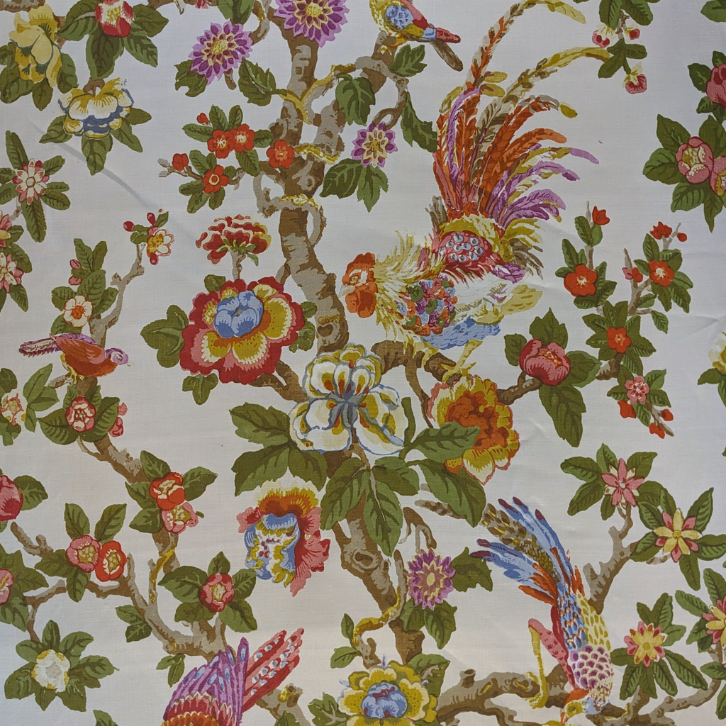 floral fabric of birds in a tree with fresh white background and green, yellow and red colours  