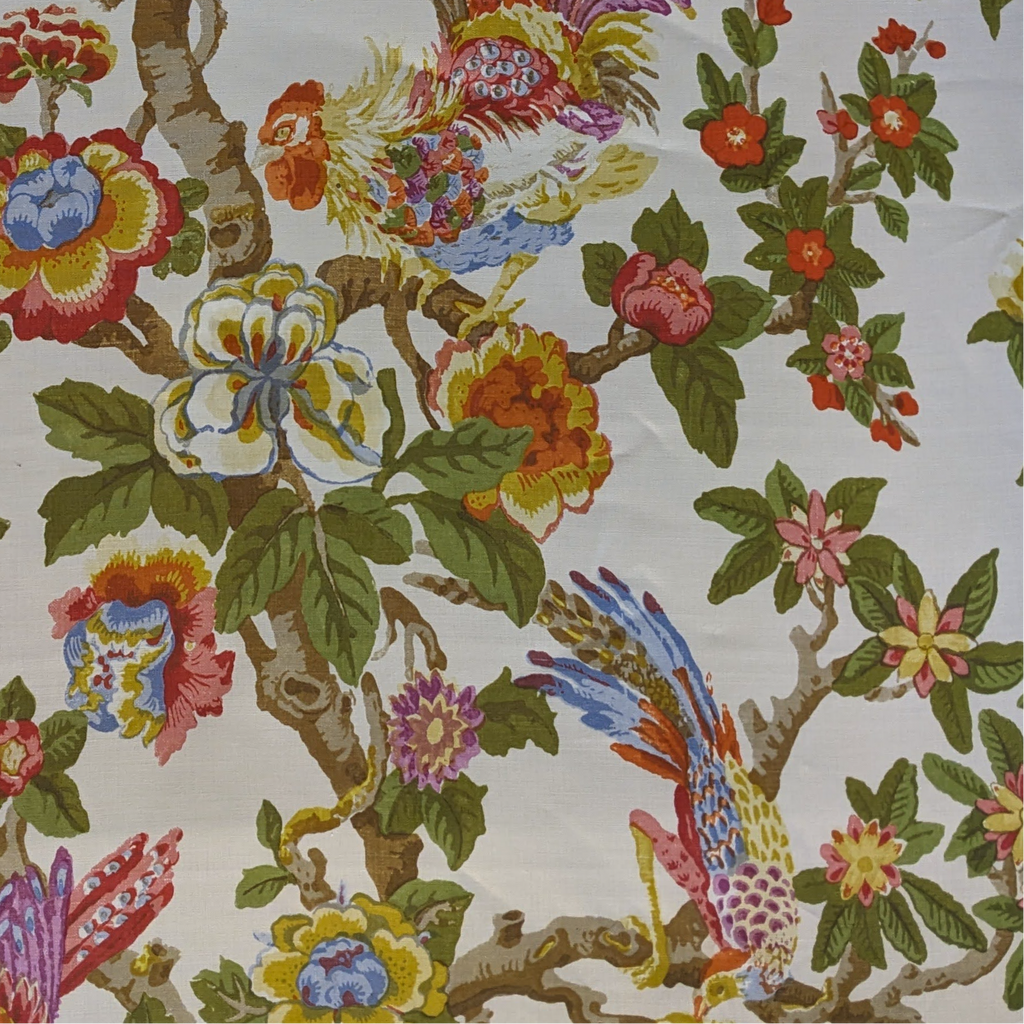 floral fabric of birds in a tree with fresh white background and green, yellow and red colours  