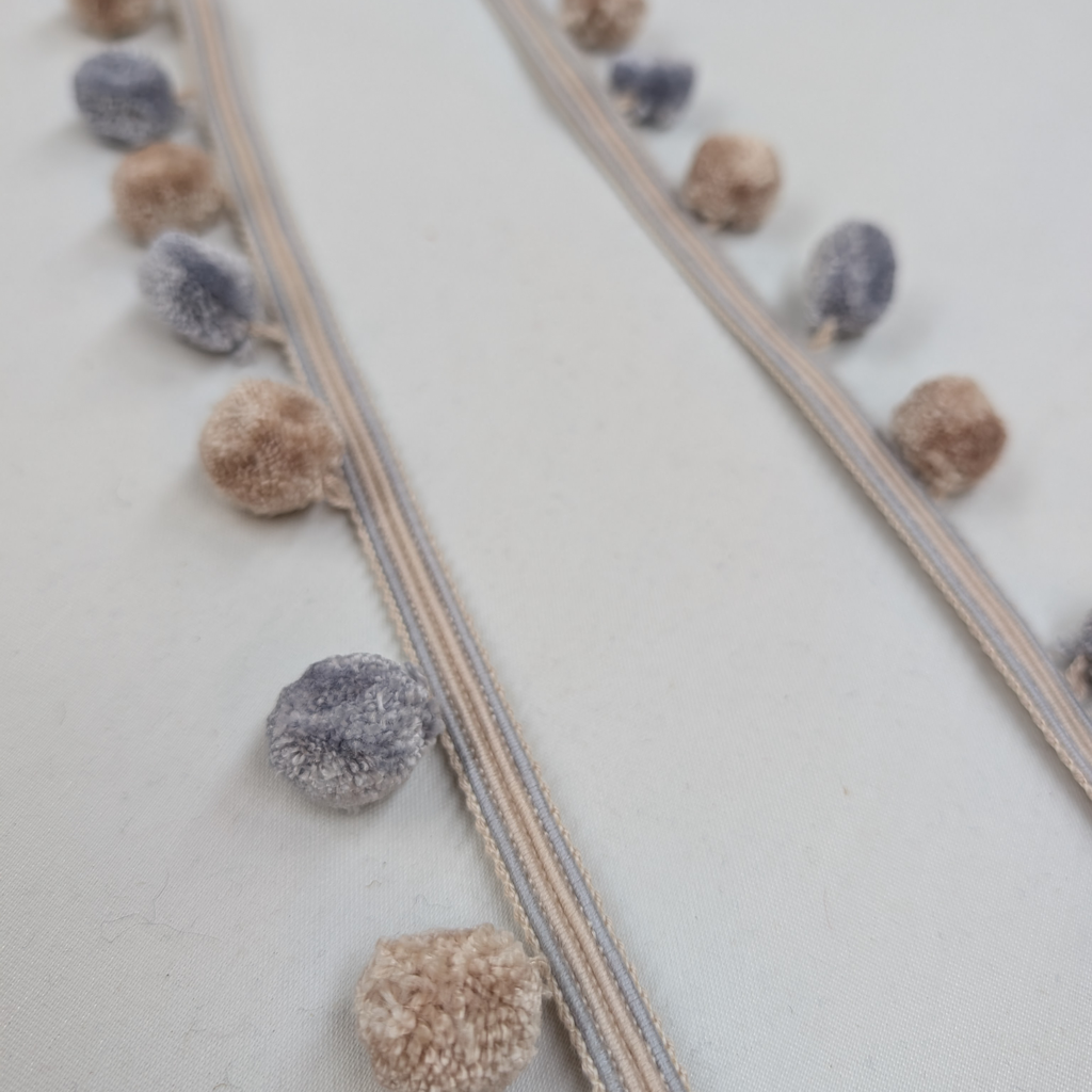 Decorative ribbon with pom-poms on a light background