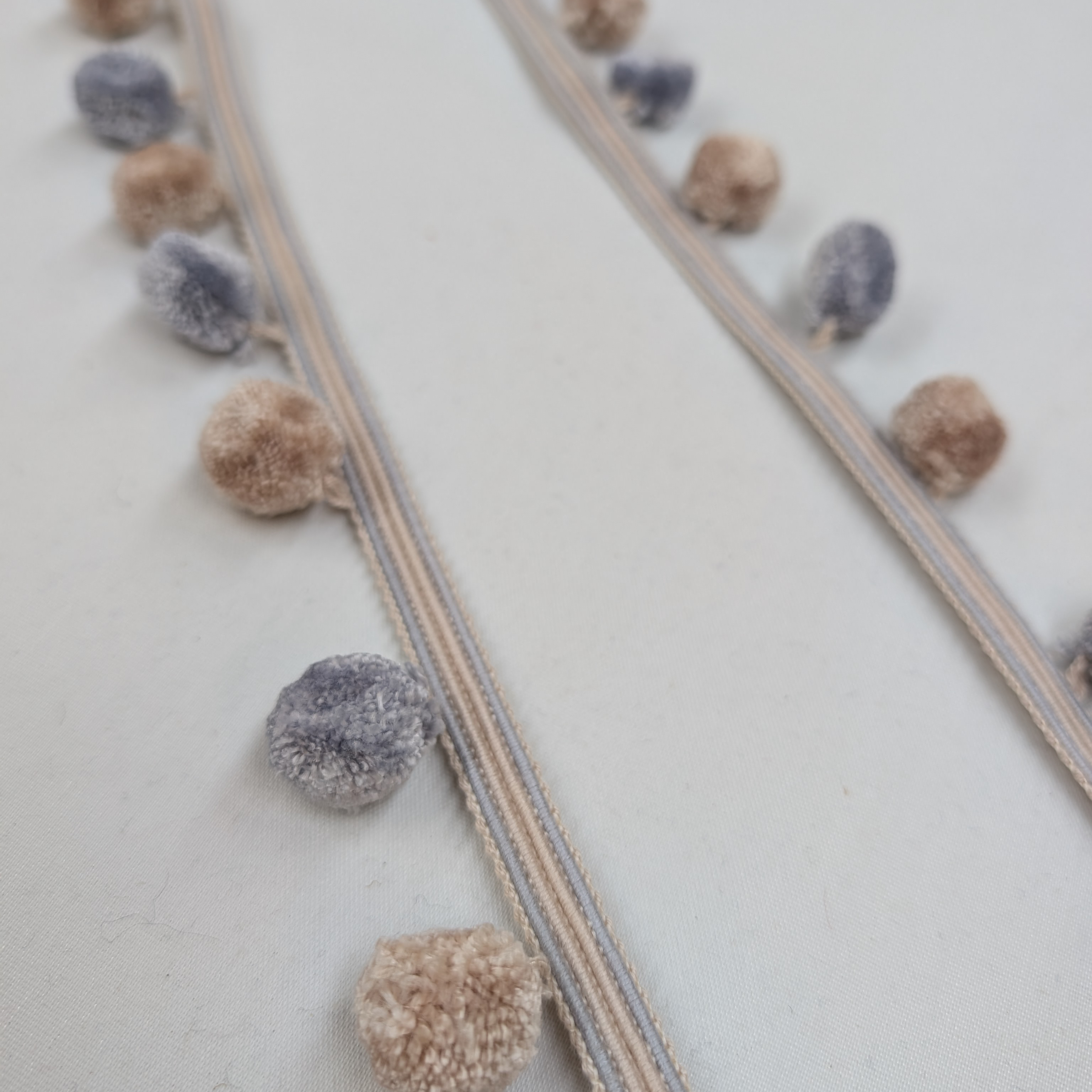 Decorative ribbon with pom-poms on a light background