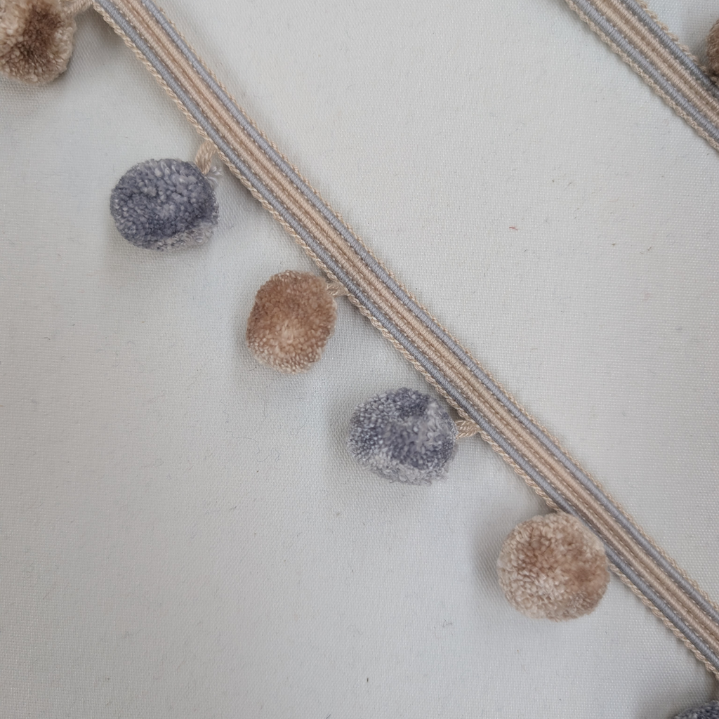 Decorative garland with pom-poms on a textured surface