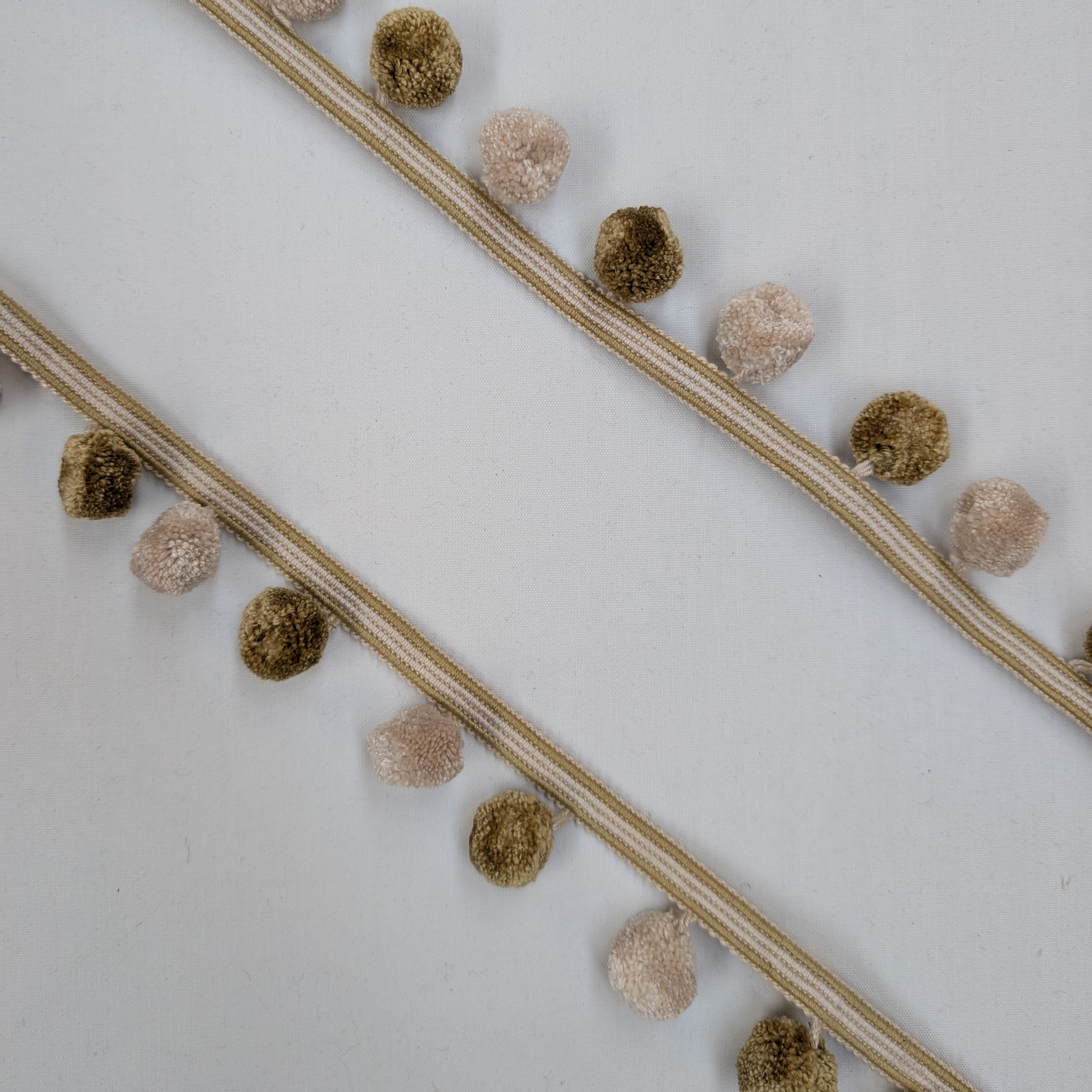 Decorative trim with pom-poms on a white background