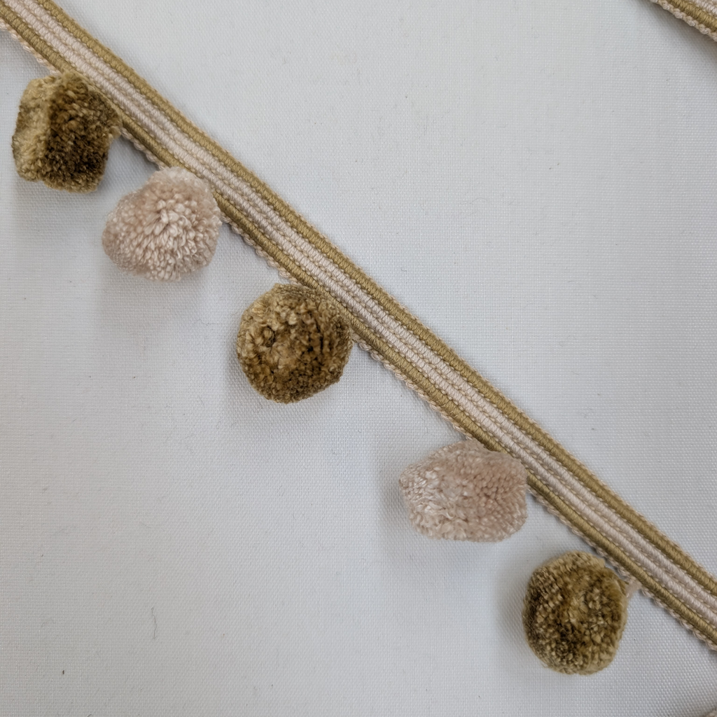 Decorative trim with pom-poms on a white background
