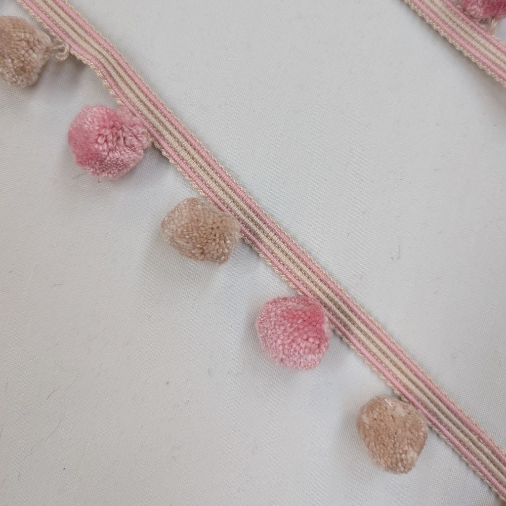 pink and beige pom-poms on a light gray background