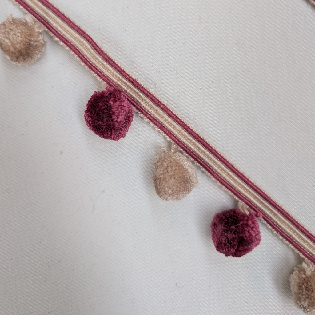 Decorative trim with pom-poms on a light background