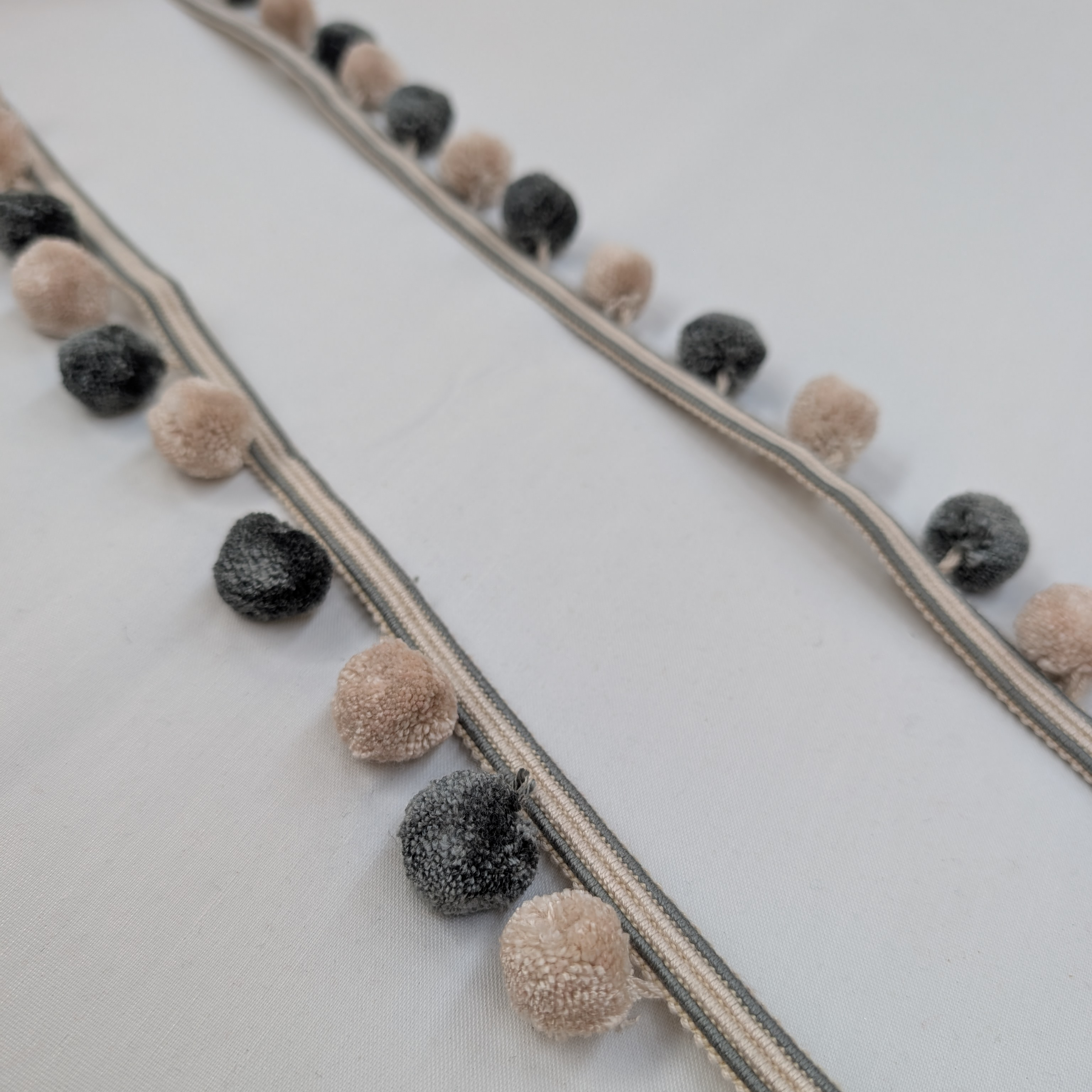 Decorative border with pom-poms on a white background