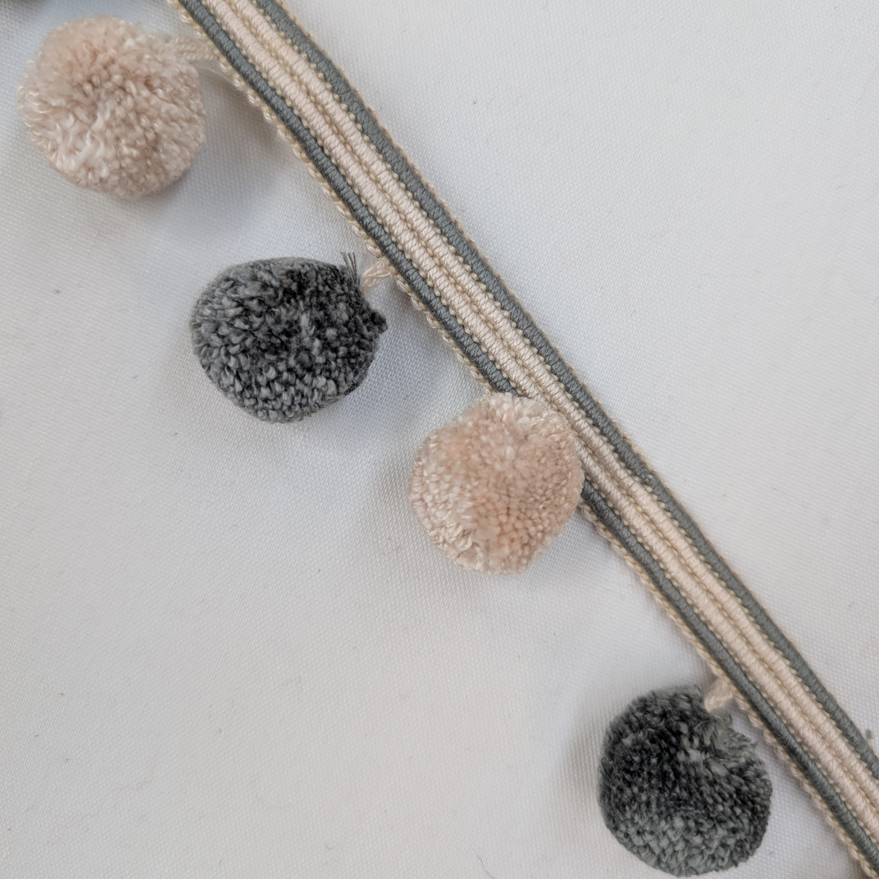 Decorative ribbon with pom-poms on a light background