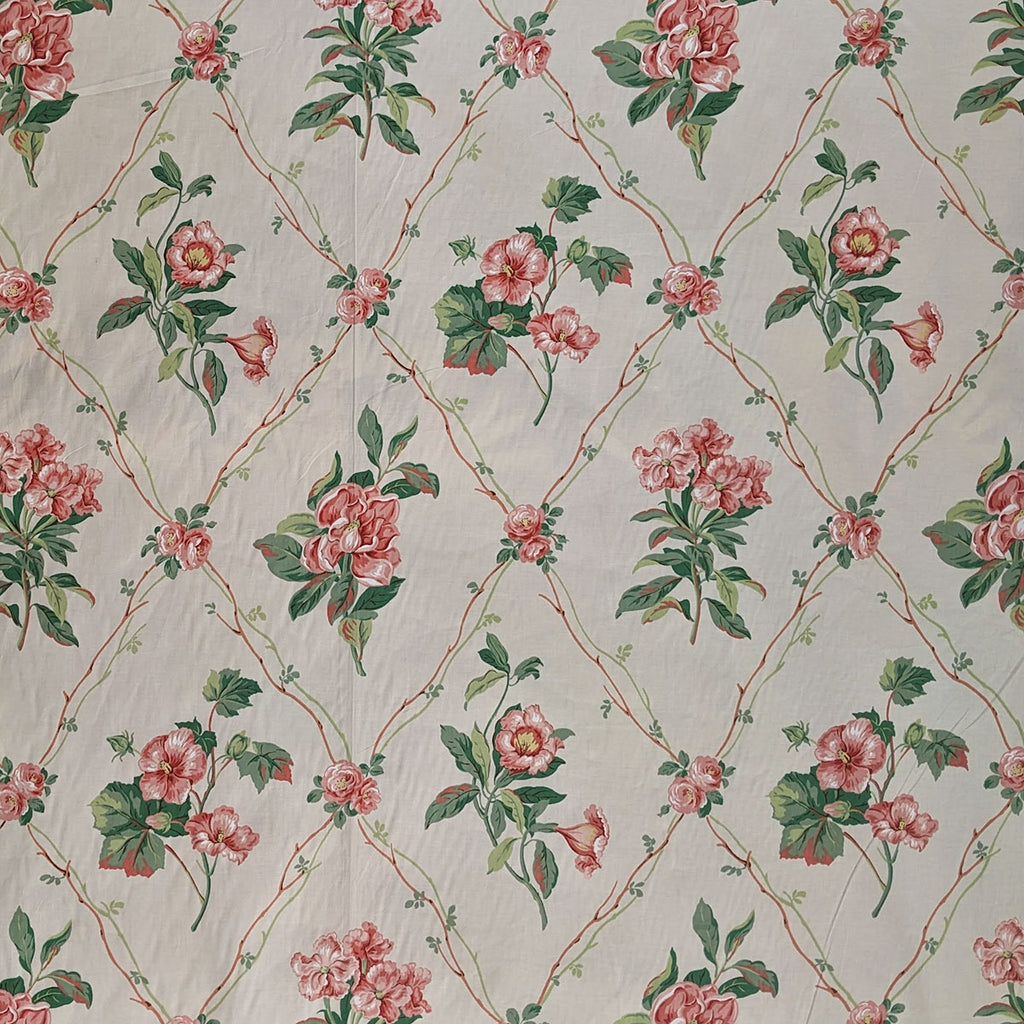 Floral patterned fabric with pink flowers and green leaves on a beige background