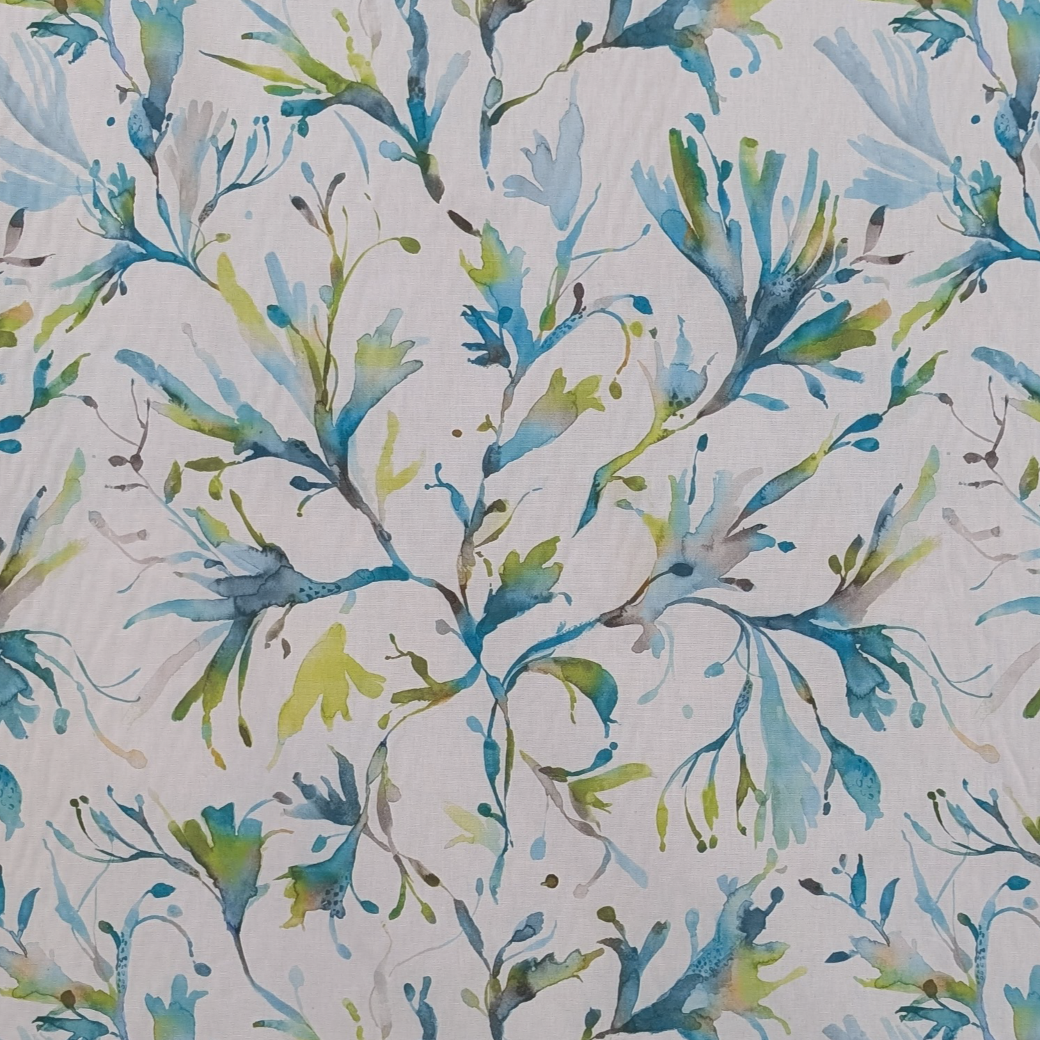 Patterned fabric with blue and green leaves on a white background