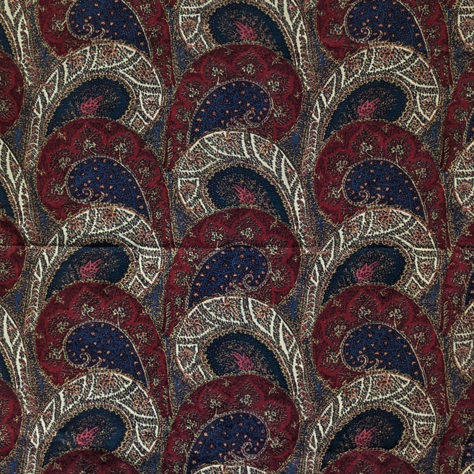 Patterned paisley fabric with red, blue, and beige colors 