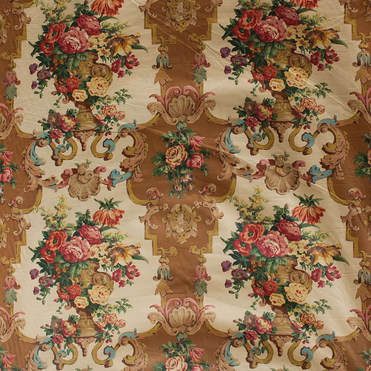 Decorative fabric with floral and baroque-style patterns on a beige background