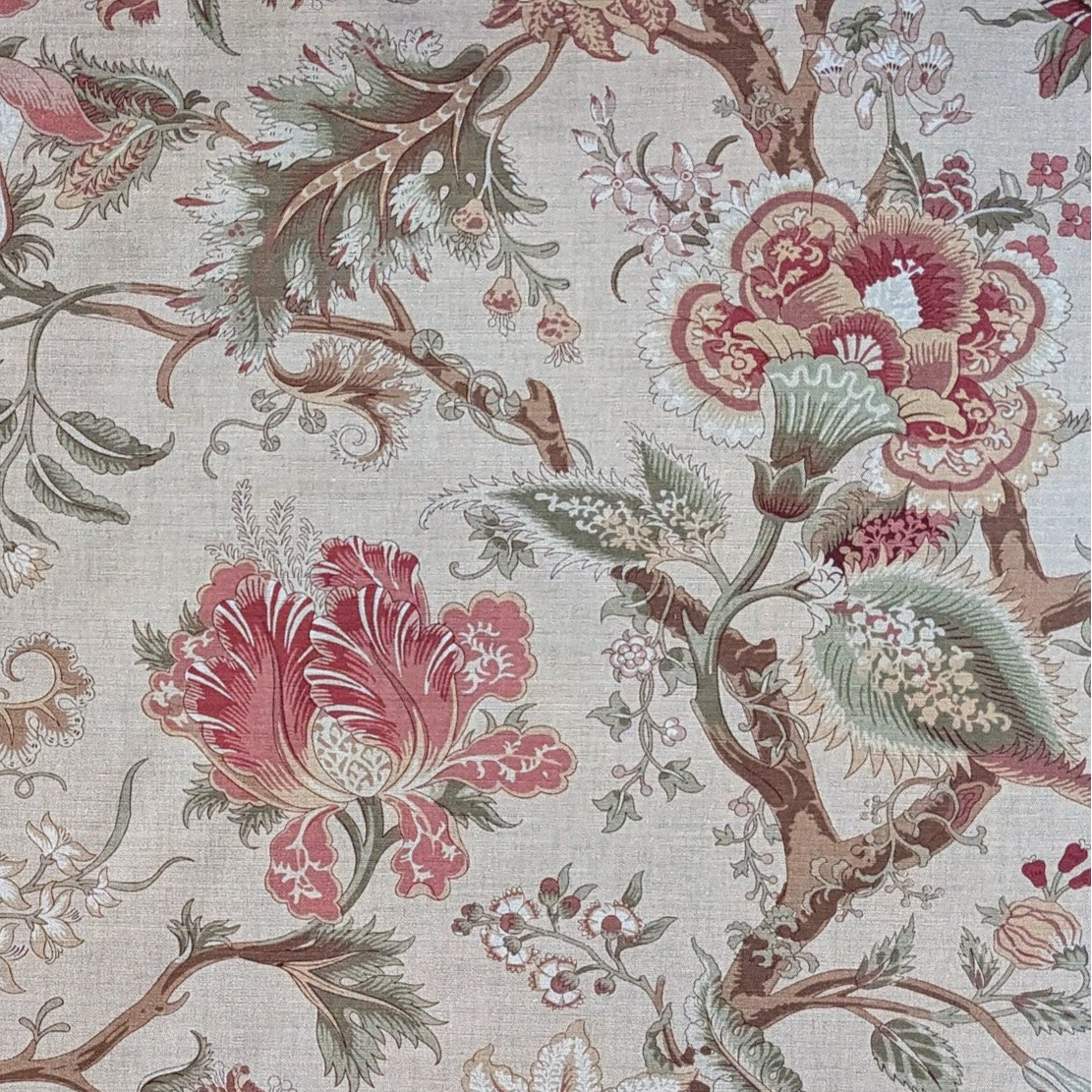 Floral and botanical patterned fabric with red, green, and beige colors on a neutral background.