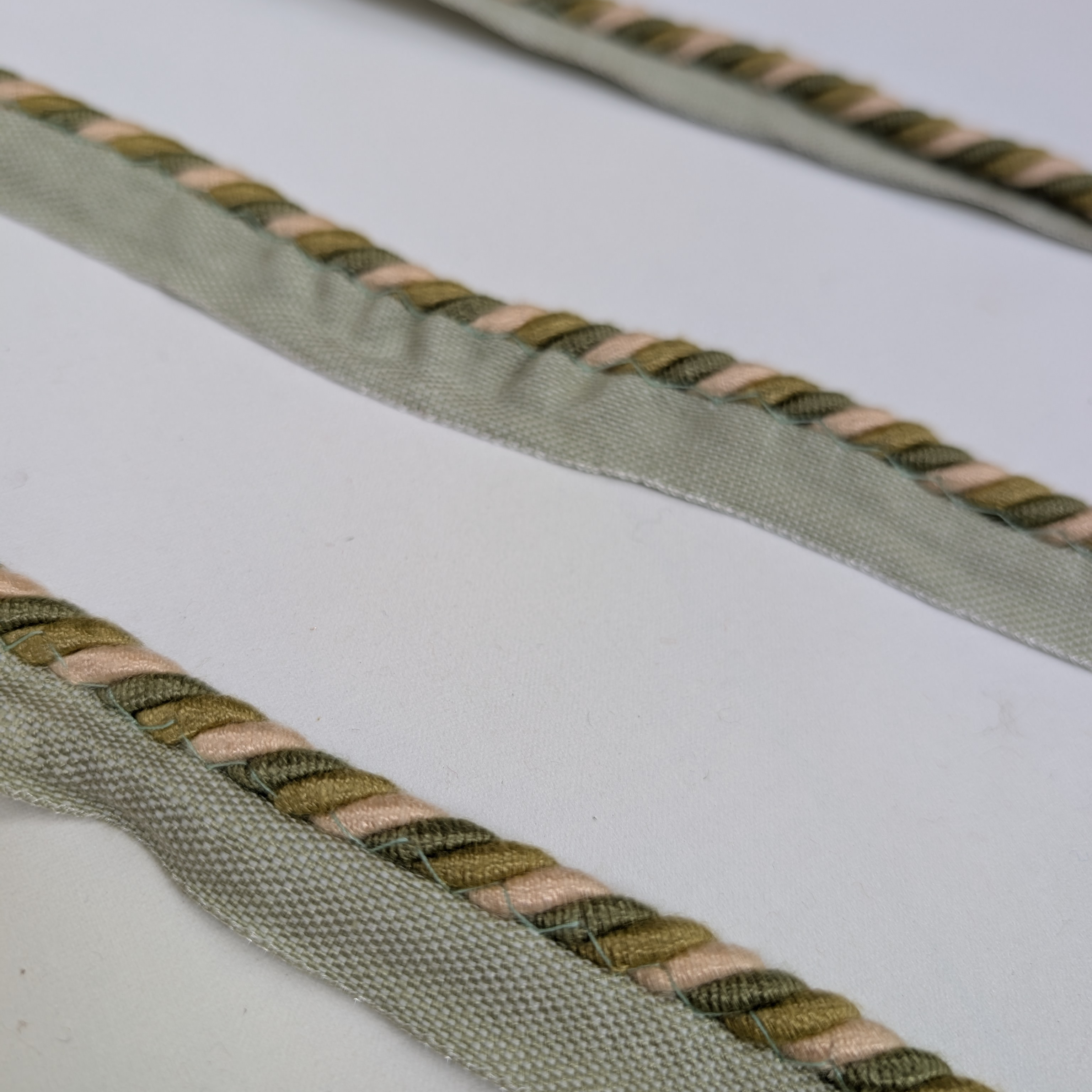 Close-up of braided green and beige cord on a white background