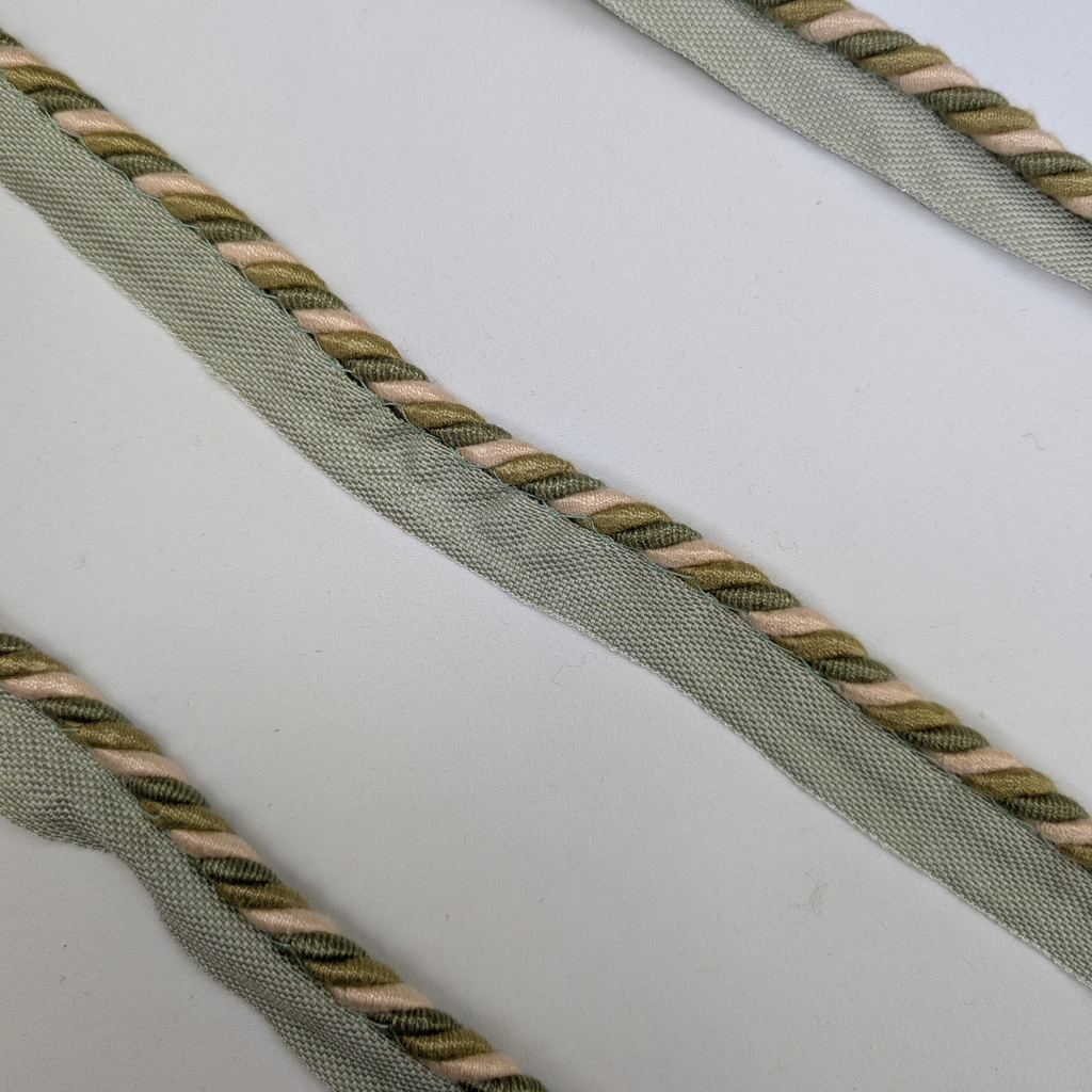 Close-up of green and beige braided rope on a white background