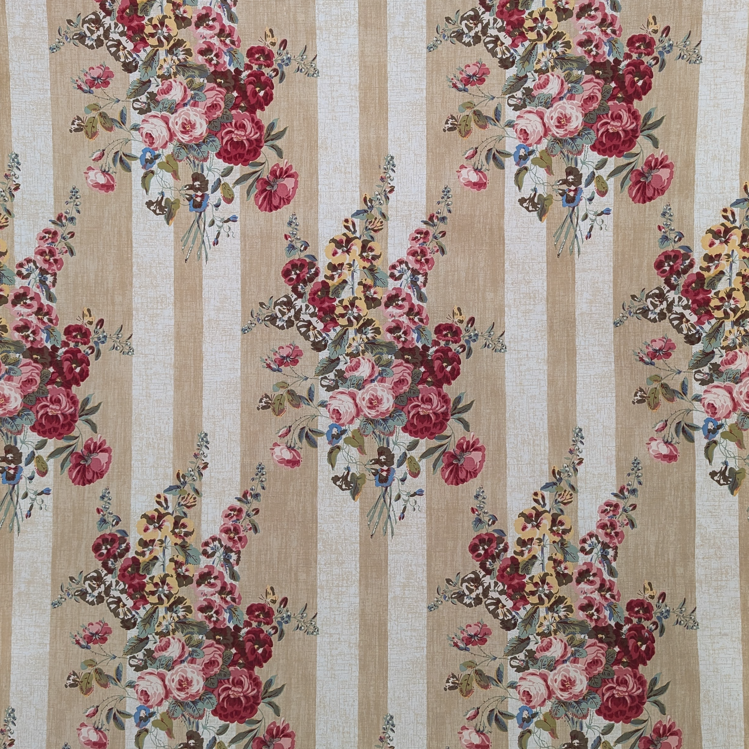 Floral patterned fabric with pink and red flowers on a beige and white striped background