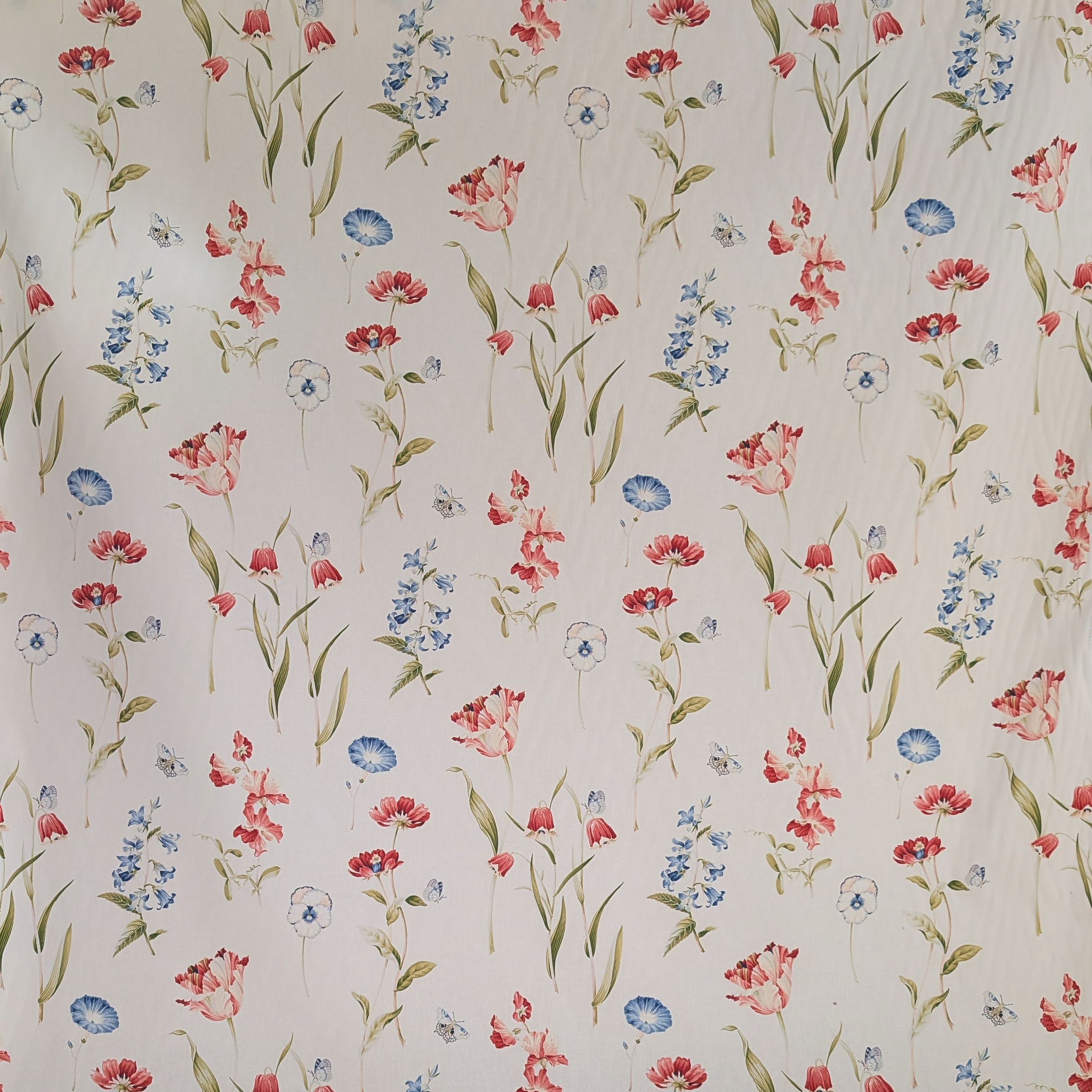 Floral patterned fabric with red, pink, and blue flowers on a beige background