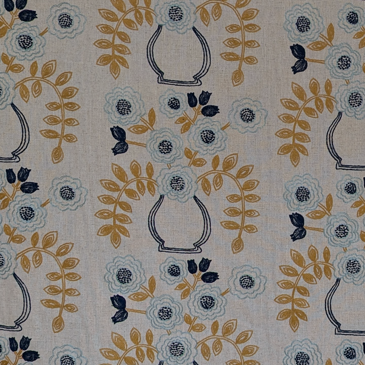 Patterned fabric with floral and vase designs on a beige background