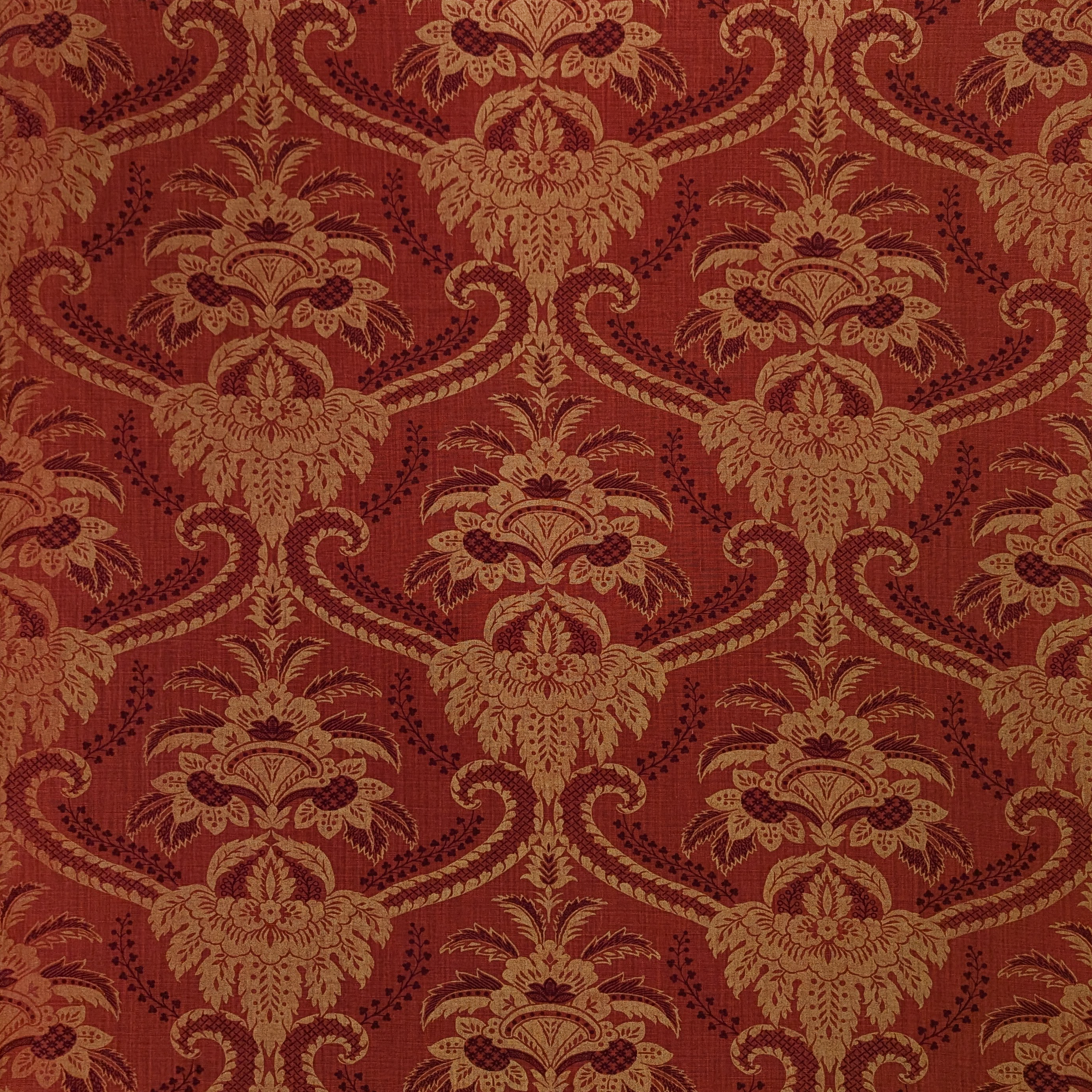 Decorative damask fabric pattern with intricate design on a red background