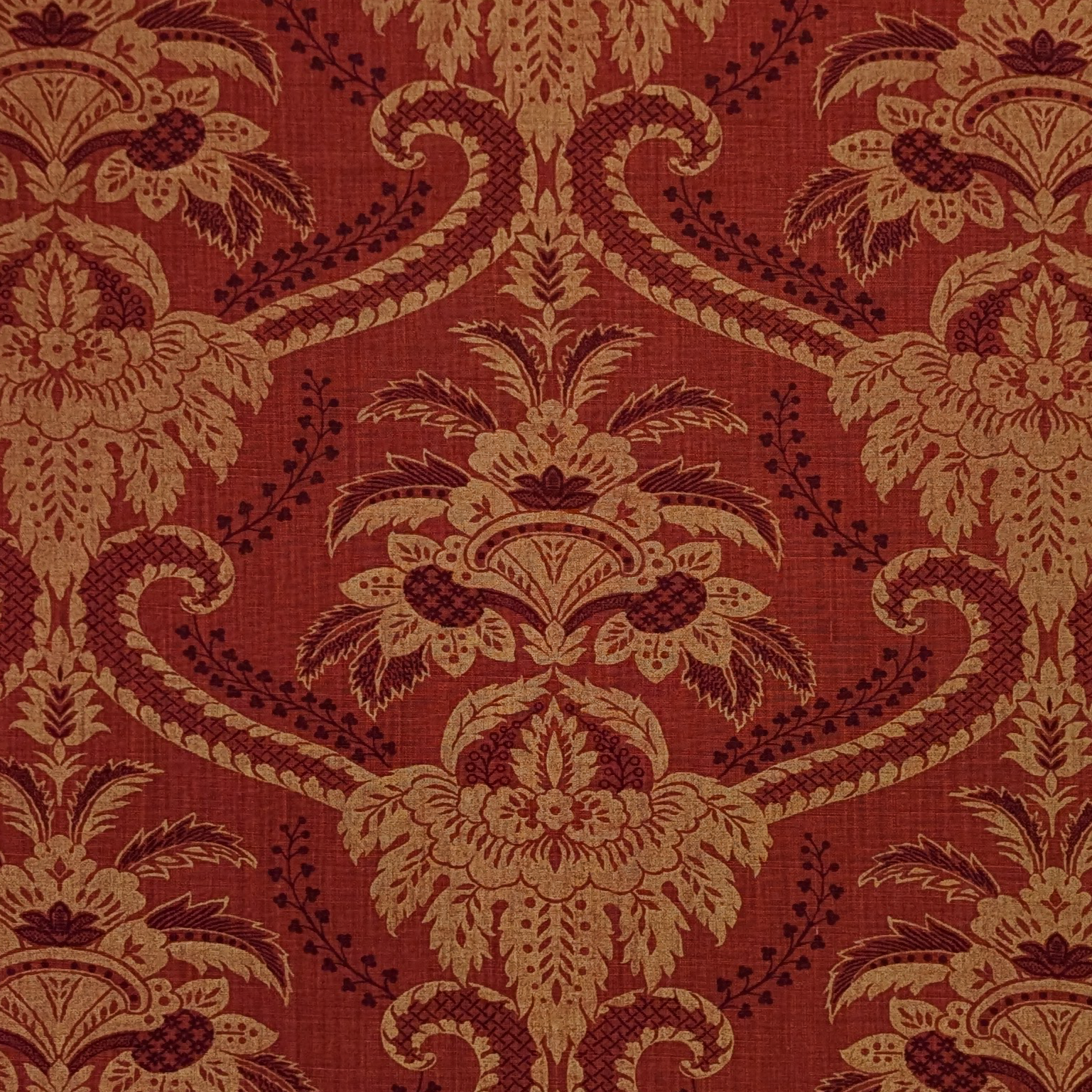 Decorative fabric pattern with intricate design on a red background
